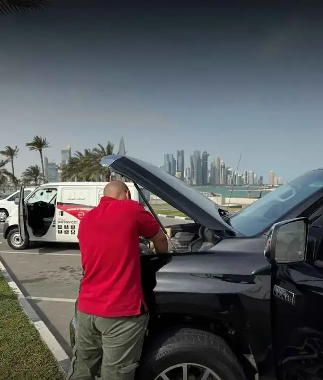 Mobile car battery technician serving Doha Qatar skyline